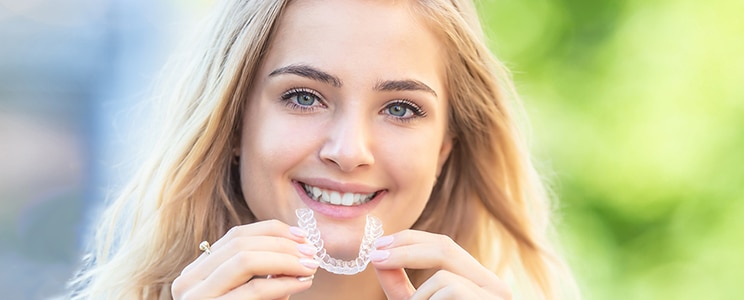 teen girl putting invisalign in mouth